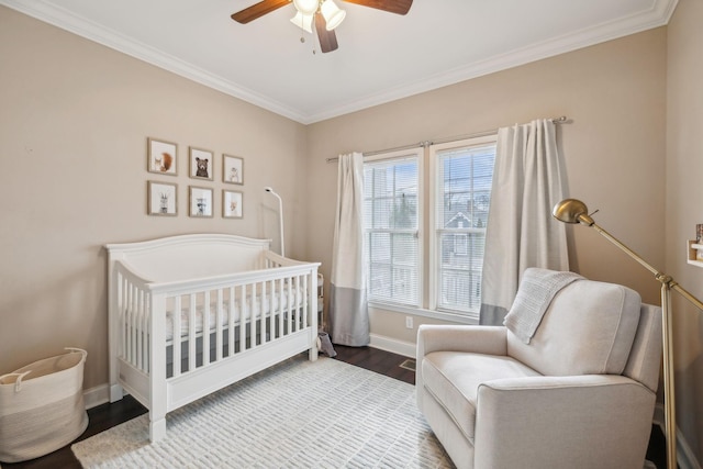 bedroom featuring wood-type flooring, a nursery area, crown molding, and ceiling fan