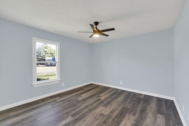 empty room featuring a textured ceiling, ceiling fan, and dark wood-type flooring