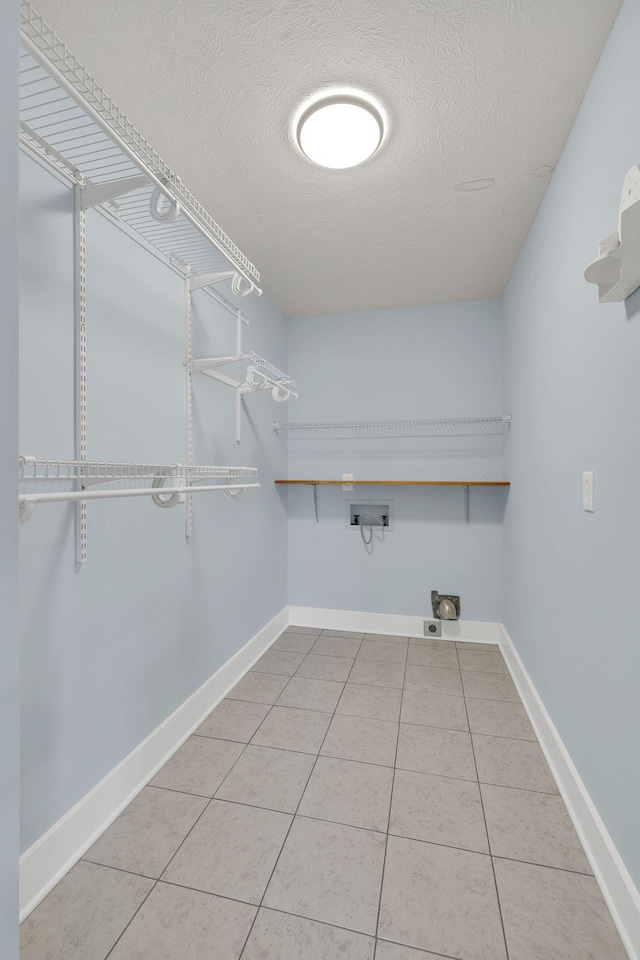 washroom featuring tile patterned flooring, a textured ceiling, and hookup for a washing machine