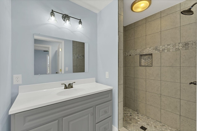 bathroom with vanity and tiled shower