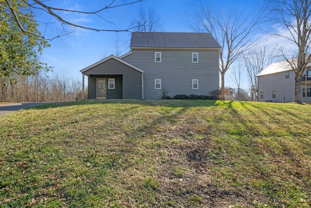 rear view of house featuring a yard