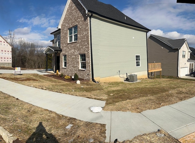 view of home's exterior featuring a lawn and central air condition unit