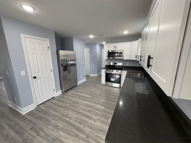 kitchen featuring white cabinetry, stainless steel appliances, sink, and hardwood / wood-style floors