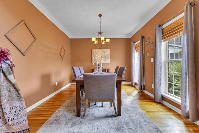 dining space with ornamental molding, light hardwood / wood-style flooring, plenty of natural light, and a notable chandelier