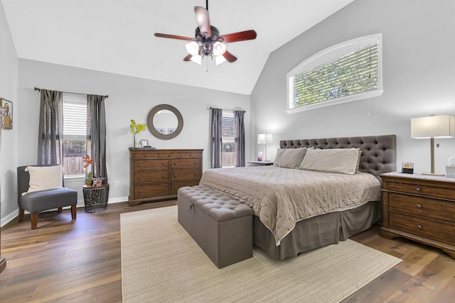 bedroom with vaulted ceiling, multiple windows, ceiling fan, and dark hardwood / wood-style floors