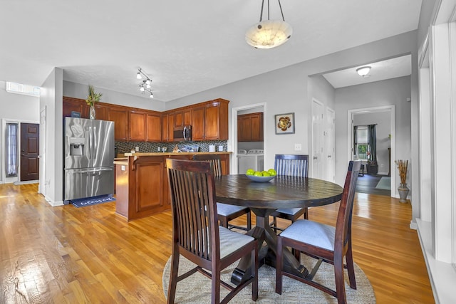 dining room featuring separate washer and dryer and light hardwood / wood-style floors