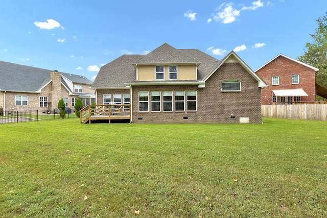 rear view of house featuring a lawn and a deck