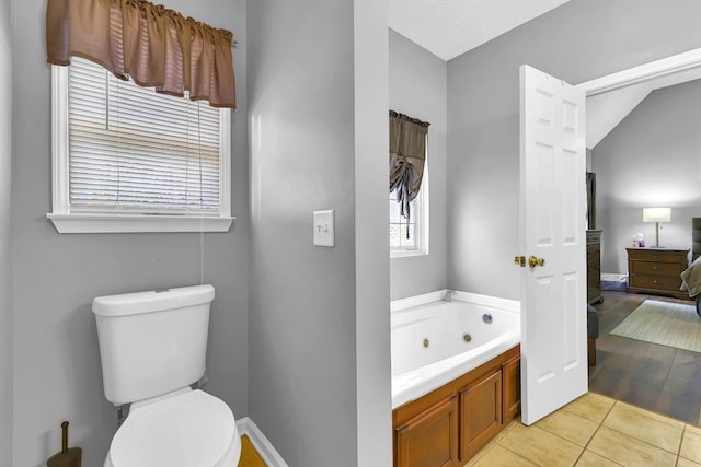 bathroom with toilet, tile patterned floors, and a tub