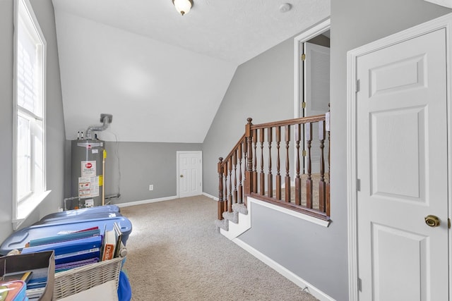 interior space with carpet flooring, lofted ceiling, and water heater