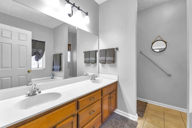 bathroom featuring tile patterned floors, vanity, and a textured ceiling