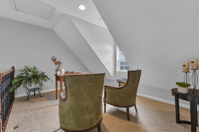 sitting room with a textured ceiling, carpet floors, and lofted ceiling