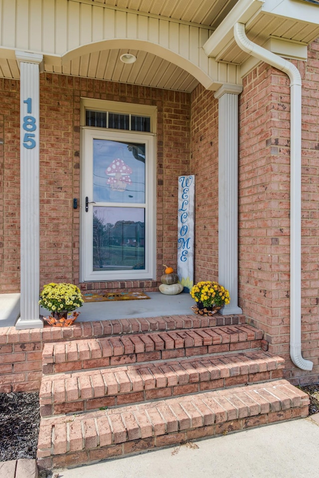 view of exterior entry featuring covered porch