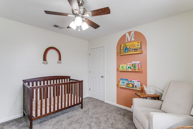 carpeted bedroom with a nursery area and ceiling fan