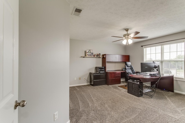 home office with a textured ceiling, carpet floors, and ceiling fan