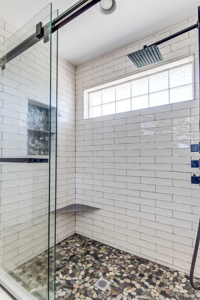 bathroom featuring a shower with door