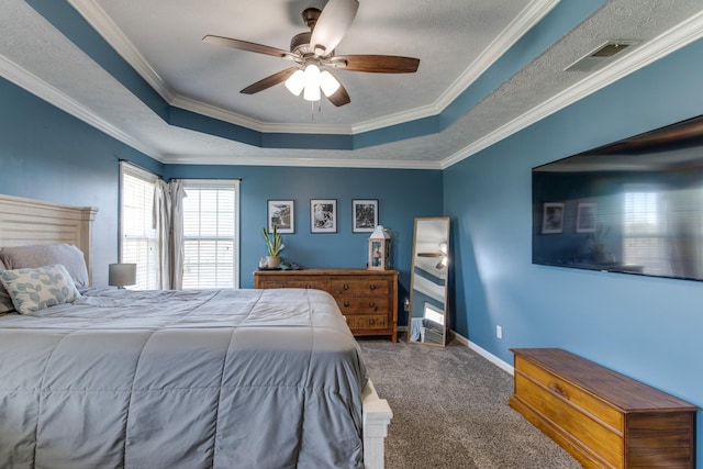 bedroom featuring crown molding, a textured ceiling, a tray ceiling, ceiling fan, and carpet