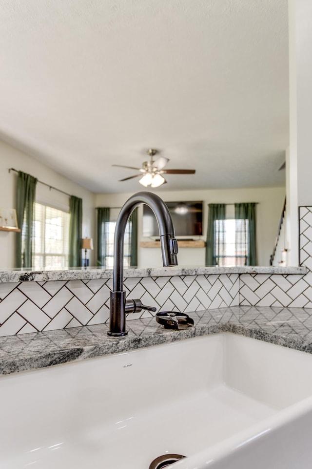 room details with ceiling fan, sink, and backsplash