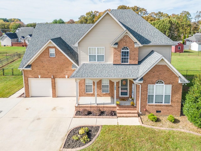 front of property featuring a garage, a front yard, and covered porch