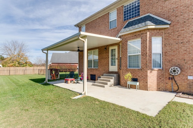 rear view of house with ceiling fan, a yard, and a patio