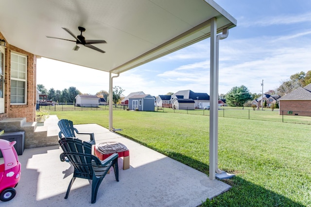 view of patio featuring ceiling fan and a storage unit