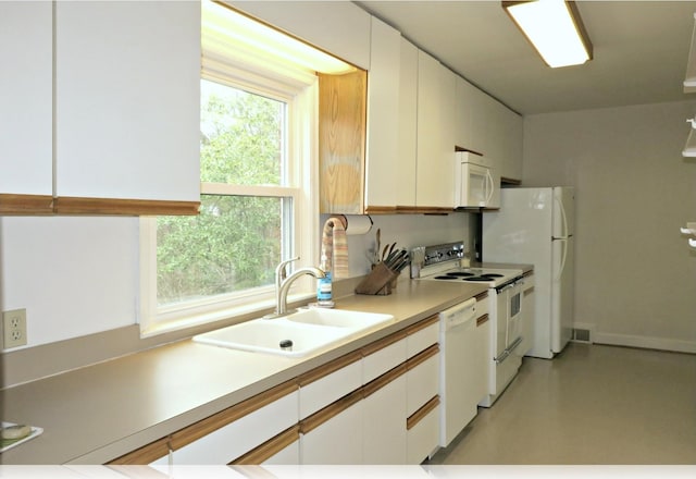 kitchen featuring white appliances, white cabinetry, and sink