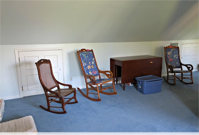 sitting room featuring carpet floors and vaulted ceiling