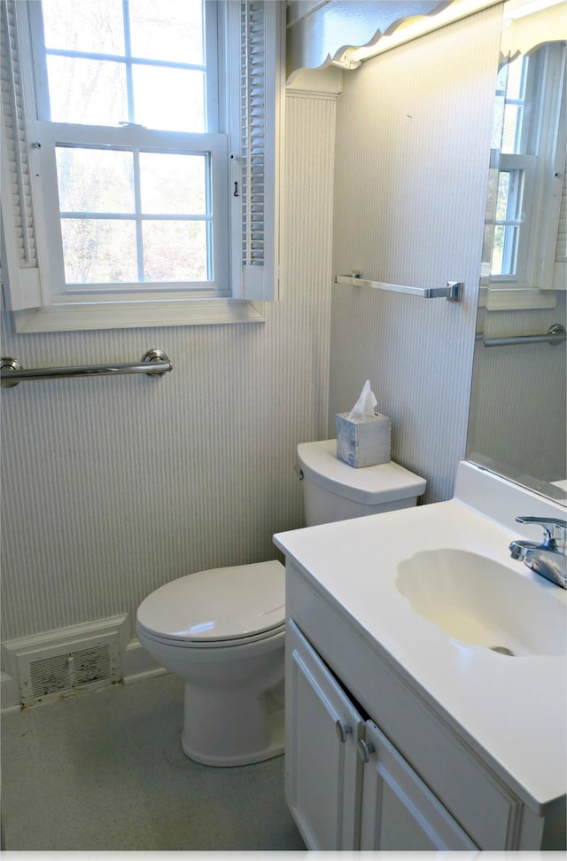 bathroom with a wealth of natural light, vanity, and toilet