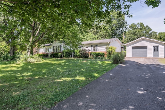 view of front of property featuring a garage, an outbuilding, and a front lawn