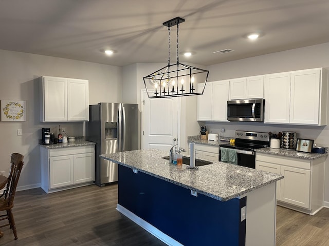 kitchen featuring white cabinetry, stainless steel appliances, and a kitchen island with sink