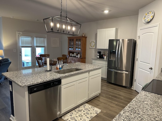 kitchen with light stone countertops, white cabinetry, stainless steel appliances, and a chandelier