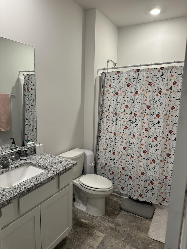 bathroom featuring a shower with curtain, vanity, and toilet