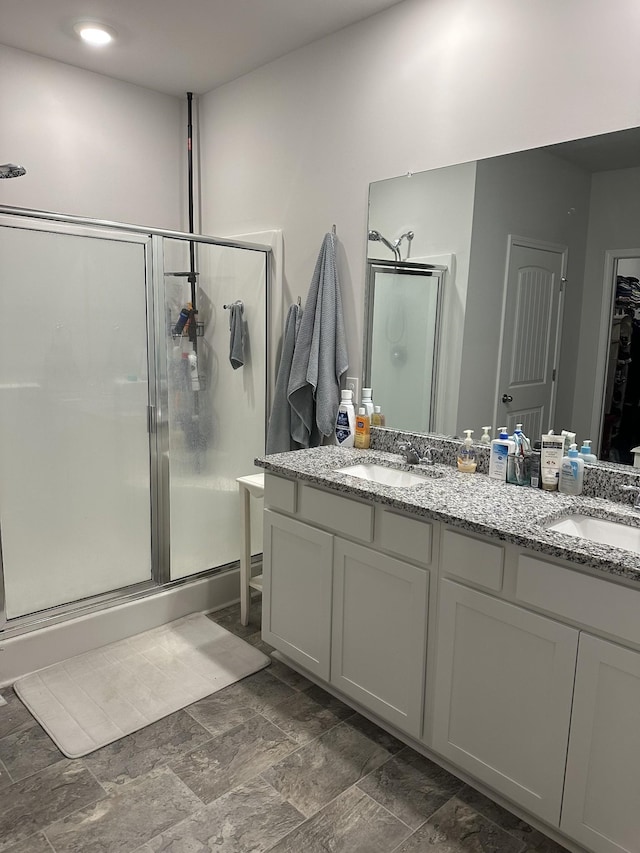 bathroom with vanity and a shower with door