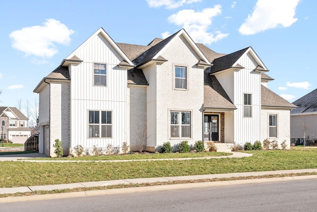 modern inspired farmhouse featuring a garage and a front lawn