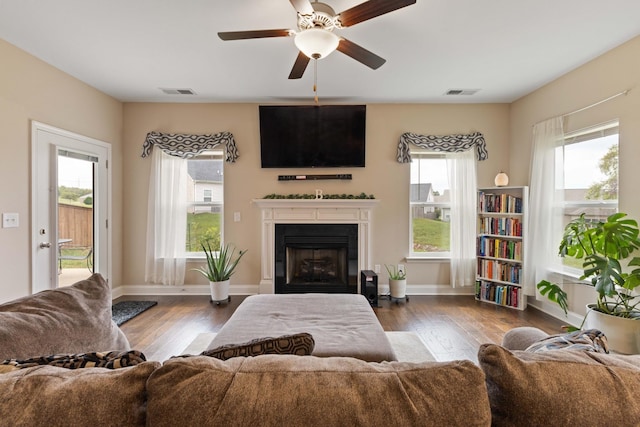 living room featuring ceiling fan and dark wood-type flooring