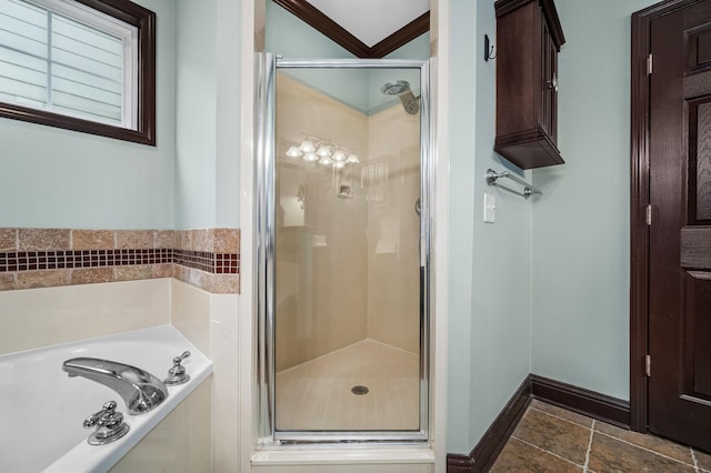 bathroom with ornamental molding and shower with separate bathtub