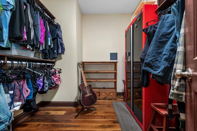 walk in closet with dark hardwood / wood-style flooring