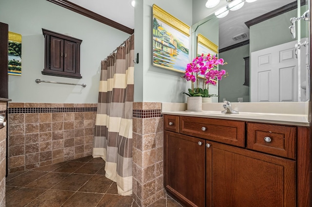 bathroom with tile patterned floors, vanity, crown molding, and tile walls