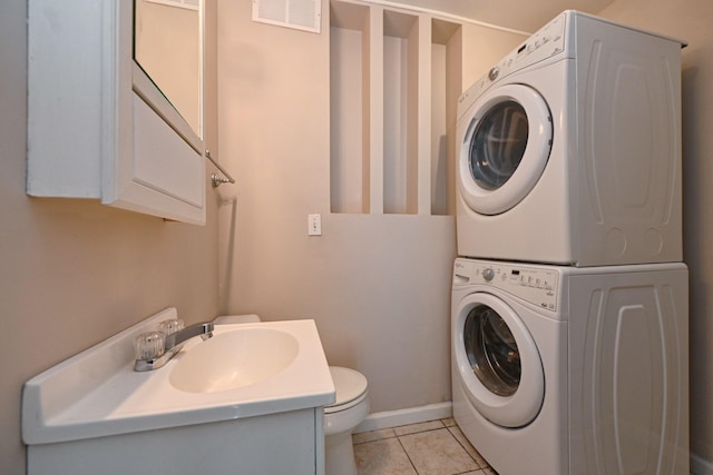 clothes washing area with sink, stacked washer / dryer, and light tile patterned flooring