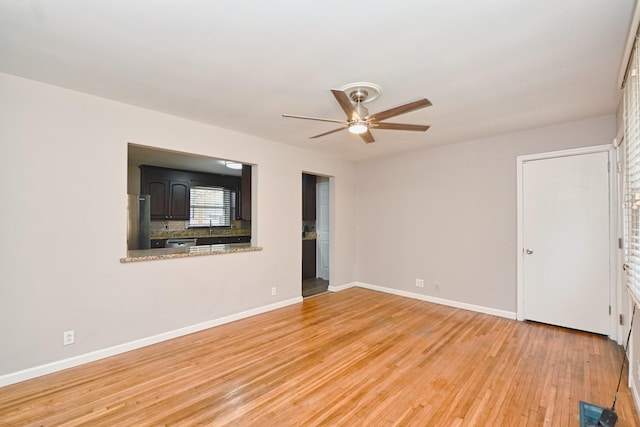 spare room with light hardwood / wood-style floors, ceiling fan, and sink