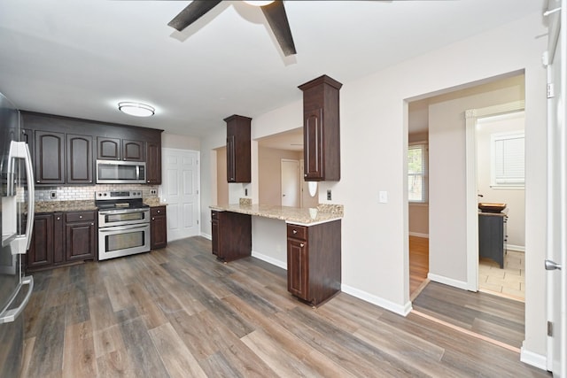 kitchen featuring decorative backsplash, dark hardwood / wood-style flooring, dark brown cabinetry, and stainless steel appliances