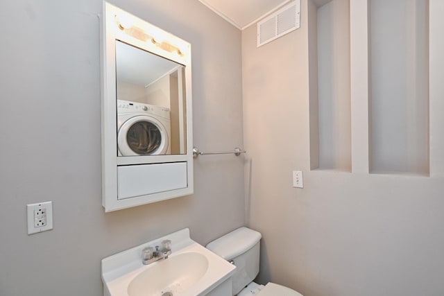 bathroom with washer / clothes dryer, toilet, and sink