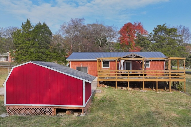 back of house featuring a lawn and a wooden deck