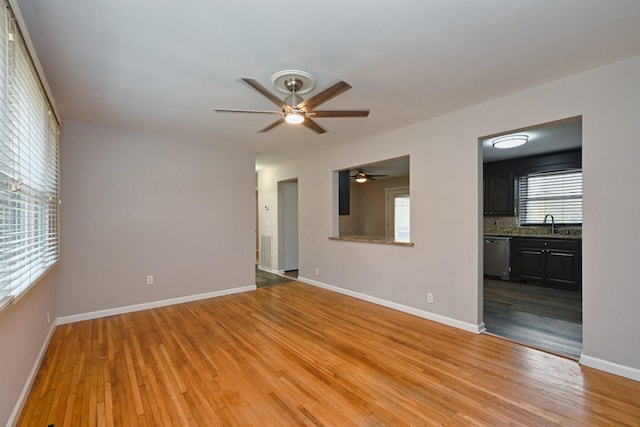 unfurnished room with light hardwood / wood-style flooring, ceiling fan, and sink