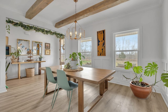 dining room featuring light hardwood / wood-style flooring, beamed ceiling, and a chandelier