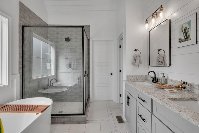 bathroom with shower with separate bathtub, vanity, vaulted ceiling, and tile patterned floors