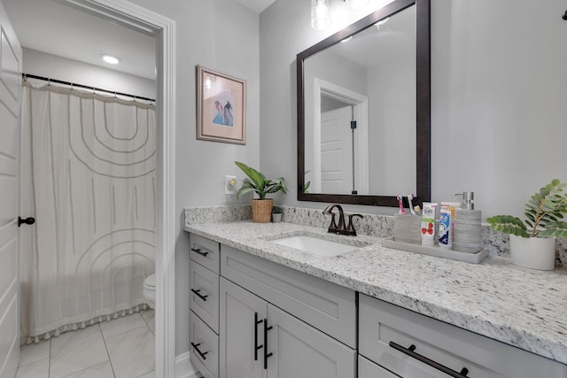 bathroom with walk in shower, vanity, and toilet