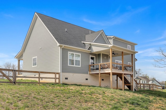 back of house with a wooden deck, ceiling fan, and a yard