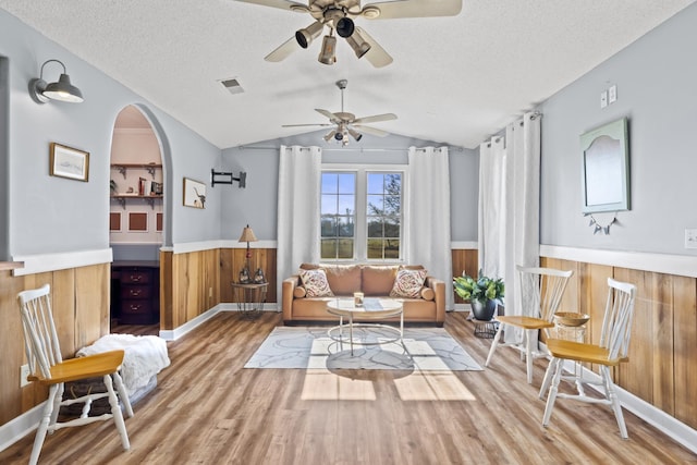 sitting room with a textured ceiling, ceiling fan, wood-type flooring, and lofted ceiling