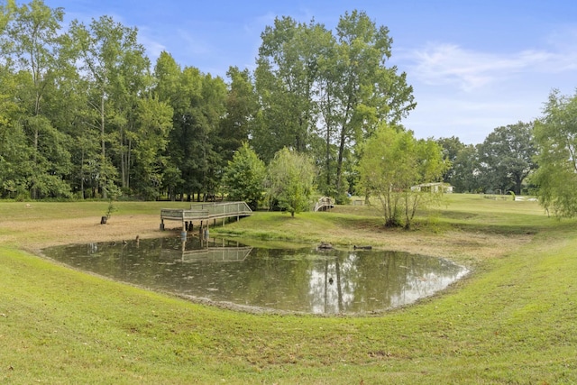 view of property's community featuring a lawn and a water view