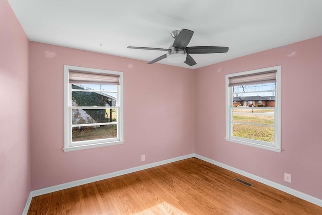 empty room with hardwood / wood-style floors and ceiling fan